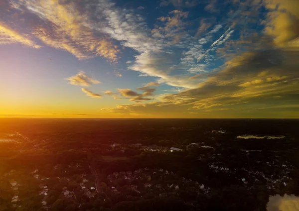 近所の早朝の日の出を示す小さな町のアパルトメントの上を飛ぶ空中トップダウンビュー — ストック写真