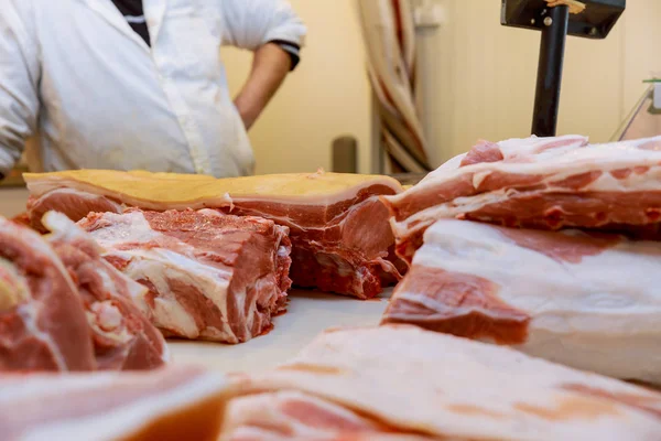 Fresh chopped pieces of meat and male hands of cutting meat pork on table. — Stock Photo, Image