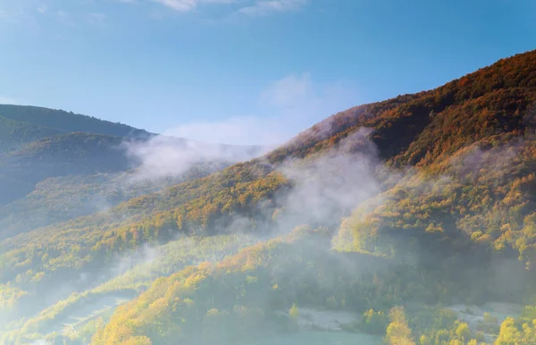 Niebla al amanecer en el paisaje de montaña en el hermoso cielo nuboso —  Fotos de Stock