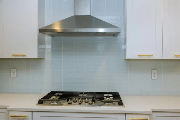Cocina gabinetes blancos con encimeras de mármol emparejado con piedra de acero inoxidable campana interior de la cocina con horno nuevo —  Fotos de Stock