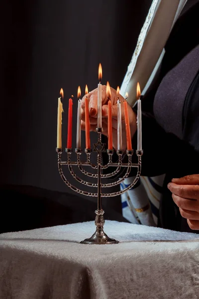 Man die kaarsen aansteekt in menorah hanukka steekt kaarsen aan — Stockfoto