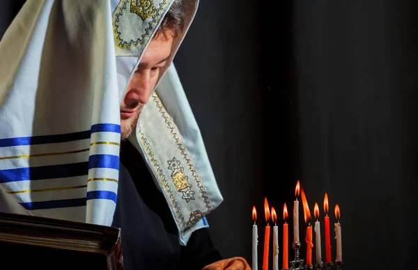 Un hombre encendiendo velas en una menorá Hombre judío en oración — Foto de Stock