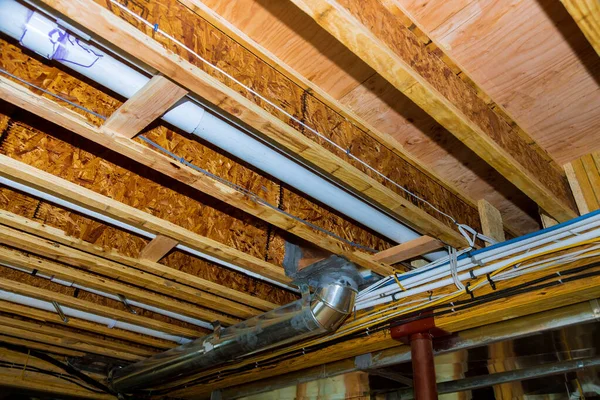 Innenwandverkleidung mit Rohrleitungen und Verkabelung im Keller des Hauses im Umbau — Stockfoto