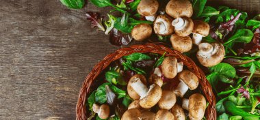 Taze yaprakları ile bir rustik ahşap tahta üzerinde üstten champignon mantar, vurdu