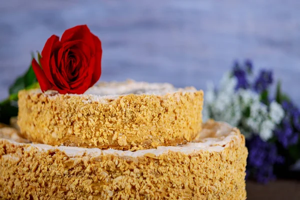 Homemade cake with crushed nuts and flowers on background — Stock Photo, Image