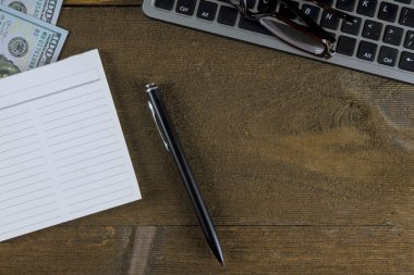 Dolar parasıyla klavye bilgisayarı. Vizyon için kalem ve gözlüklü e-ticaret.