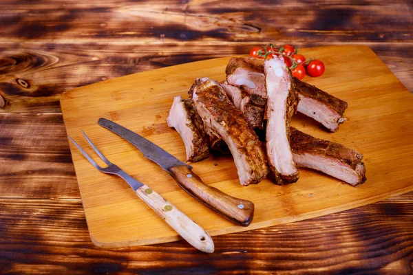 Мясо свиные ребрышки на гриле барбекю в доске на помидорах на деревянном фоне лежал плоский . — стоковое фото
