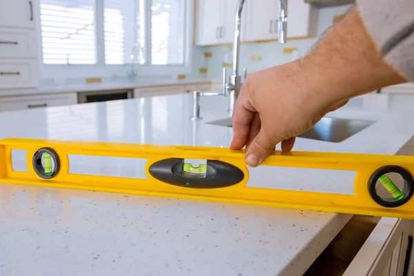 Lavoratori che installano top counter armadio interno della cucina — Foto Stock