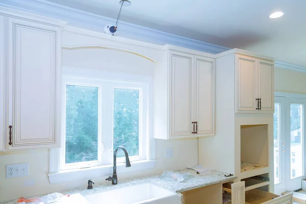 Moderna skåp med nya vitvaror och diskbänk i köket — Stockfoto