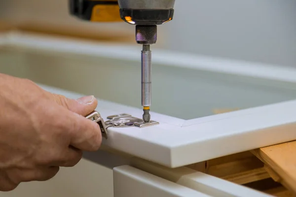 Les installateurs de charpentier une vue d'amélioration de charnière de porte d'armoire ont installé une nouvelle cuisine — Photo