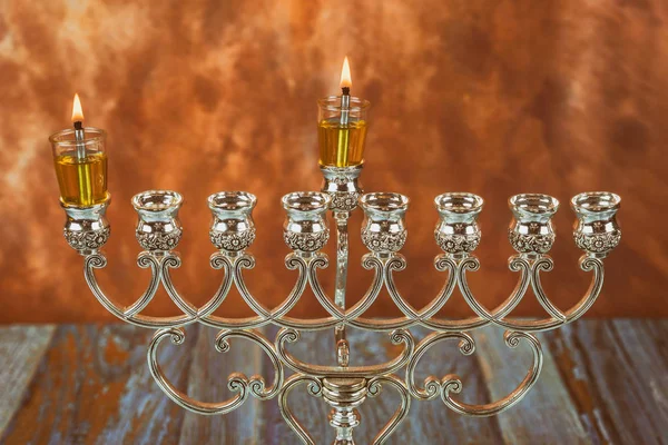 Menorah een traditionele Joodse feestdag het aansteken van de eerste kaars op een hanukkahof een brandende Chanoeka kaarsen Menorah — Stockfoto