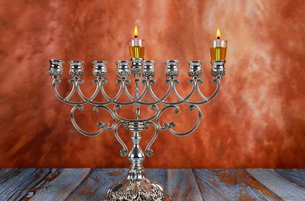 Joodse vakantie Chanoeka met het aansteken van de eerste kaars op een hanukkah menorah traditionele kandelaar — Stockfoto