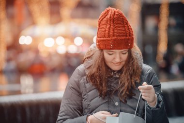 Güzel mutlu kız şehirde alışveriş yaptıktan sonra kese kağıdıyla alışverişe çıkar..