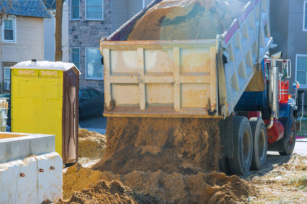 Truck pour soil on the ground in construction area.