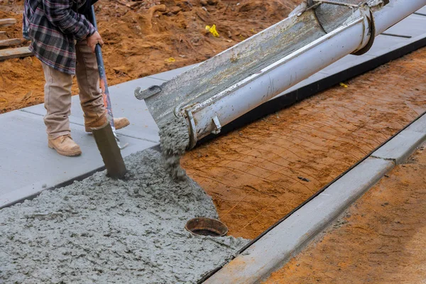 Lastbilslaster av betong hälls i betongen på en konstruktion i en trottoar — Stockfoto