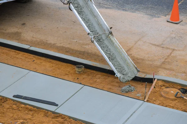 Betong som hälls från en lastbil in i en betong med trottoar — Stockfoto