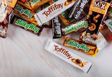 Close-up bunch of chocolate bars incorporated manufactured Toffifee, Milky way, Raffaello, snickers, Twix, Mars, hersheys clipart