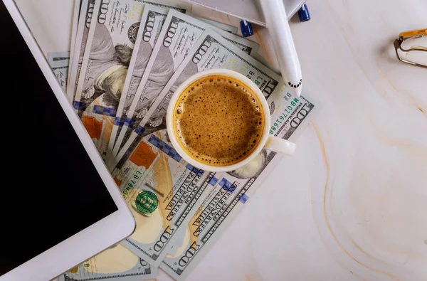 Computador tablet digital com compra de bilhetes de avião nas notas de dólar dos EUA, com avião de férias viagem xícara de café . — Fotografia de Stock