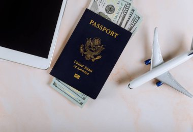 Model uçakla Amerikan pasaportu ve dolar banknotları, cihazların dokunmatik yastığına sarmal defter