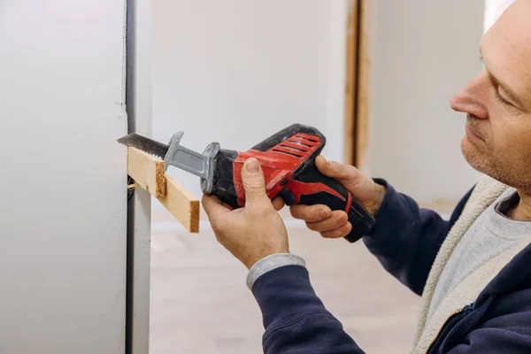 Snickare med hackzall för kapning av träplanka Konstruktionsdetaljer för installation av en träbalk hölje öppning gångväg mellan rum — Stockfoto