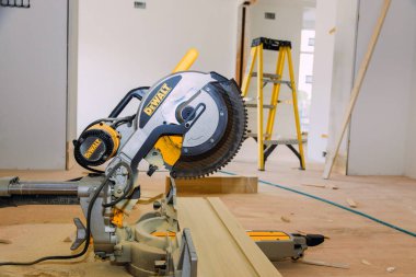 Müteahhit Dewalt dairesel testeresi kullanarak yenileme için temel kalıpları kesiyor.