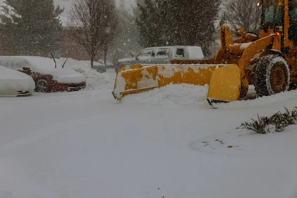 Limpiar la nieve en la carretera en el aparcamiento para los coches —  Fotos de Stock