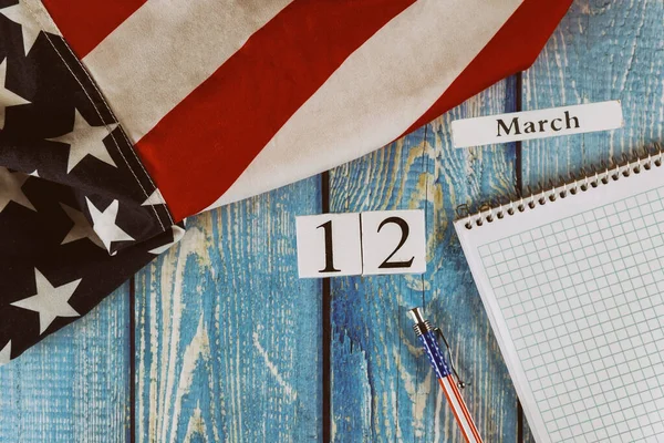 3月12日カレンダー自由と民主主義の米国のシンボルの旗空白のメモ付き。オフィスの木製のテーブルの上にペン — ストック写真