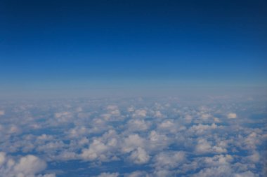 Mavi gökyüzünde beyaz bulutlar hava planından görünüyor