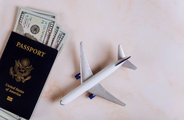 Model uçakla seyahat eden Amerikan pasaportu ve dolar banknotları.