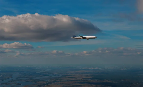El avión de pasajeros que cruza por encima de las nubes — Foto de Stock