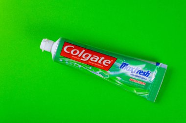 Colgate diş macunu yeşil arkaplanda izole edilmiş. Colgate, Amerikan Colgate-Palmolive tarafından üretilmiştir..