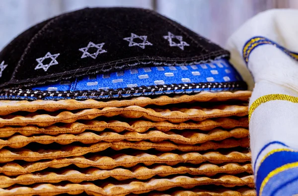 Passover matzoh jewish holiday bread with kipah and tallit over wooden table. — Stock Photo, Image