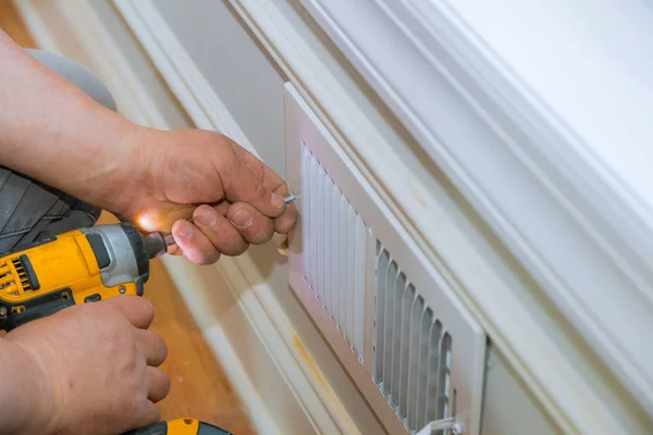 Reparación de mantenimiento, el hombre está haciendo la cubierta de ventilación de la pared — Foto de Stock