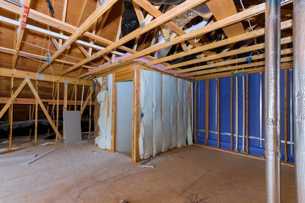 Insulation of attic with insulation material and pipe heating system a wooden beams of a roof structure — Stock Photo, Image