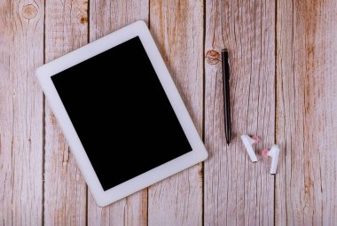 Ofis malzemeleri, kablosuz kulaklıklar ve kalemle dijital tabletli işyeri