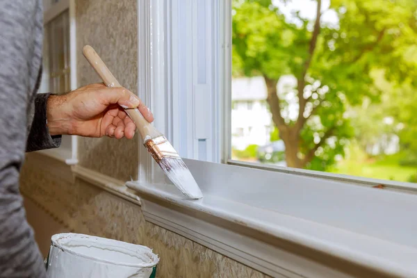 Hand with paintbrush painting a window white — Stock Photo, Image