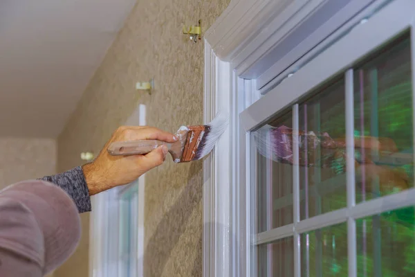 İşçi boya fırçası kullanarak ahşap pencere çerçevesi boyuyor — Stok fotoğraf