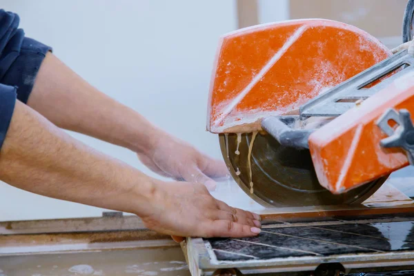 Працівник використовує ріжучу пилку для різання плитки для підлоги — стокове фото