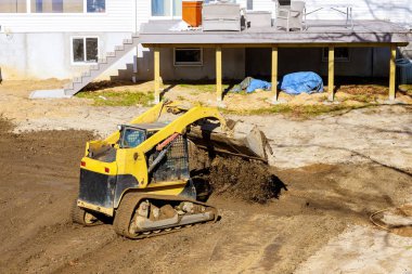 Mini buldozer ve toprak peyzaj işleri yapıyor.