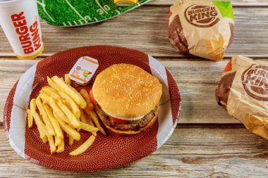 Burger King setiyle Amerikan futbolunda ahşap masada patates kızartması var.