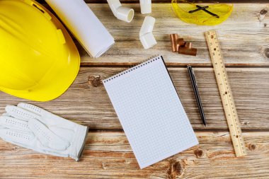 Bina inşaatı araçlar ve miğfer ile planlar üzerinde çalışma ekipmanı ile kalem ve defter üzerinde