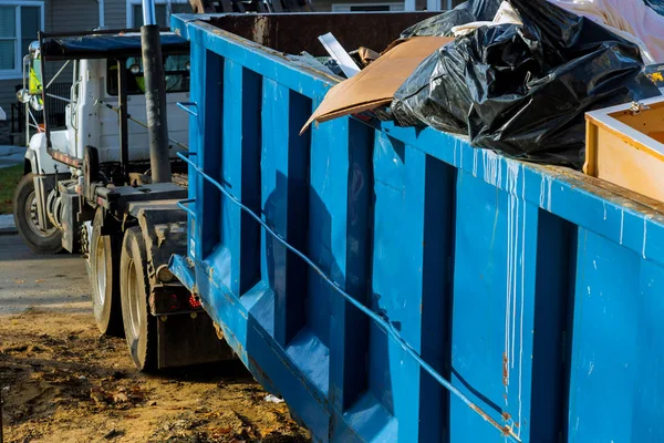 Carregando o recipiente de lixo velho e usado material de construção no novo canteiro de obras de construção . — Fotografia de Stock