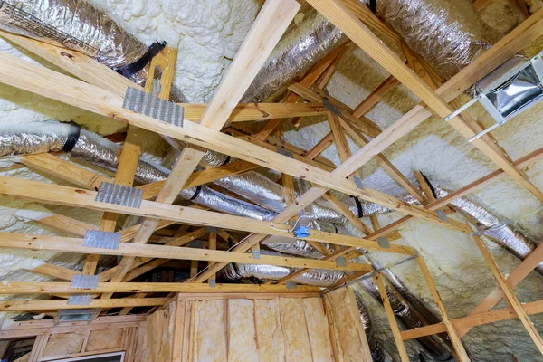 Installing attic insulation material is sprayed with liquid foam of heating system on the roof — 스톡 사진