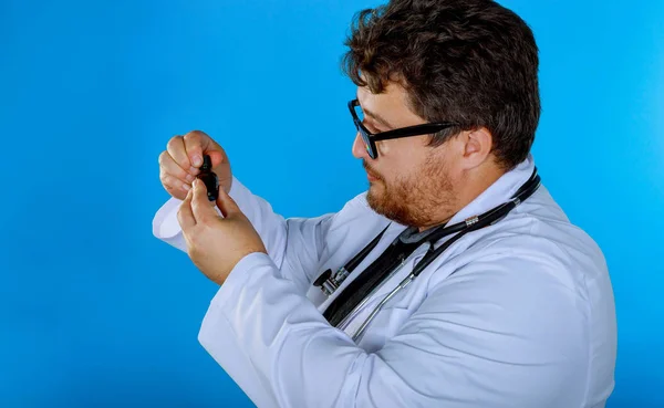 Доктор в окулярах тримає пляшку і перевіряє ліки . — стокове фото