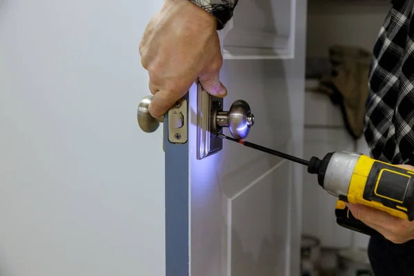 Mãos Woodworker está instalando o punho portas — Fotografia de Stock