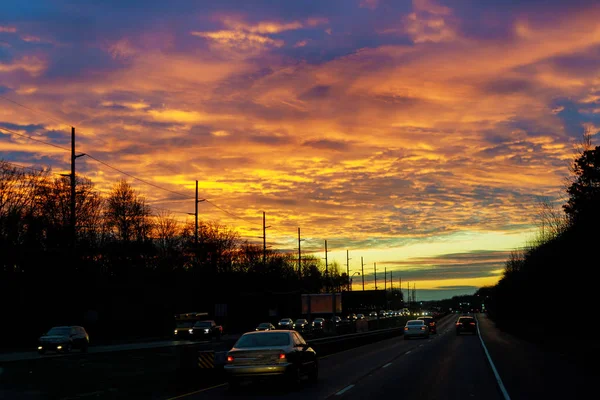 Tráfego na estrada no belo céu do nascer do sol com nuvens — Fotografia de Stock