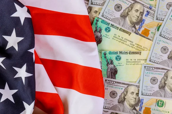 Uyarıcı Amerikan ekonomik vergi iadesi çeki ABD bayrağı ve ABD doları banknotuyla — Stok fotoğraf