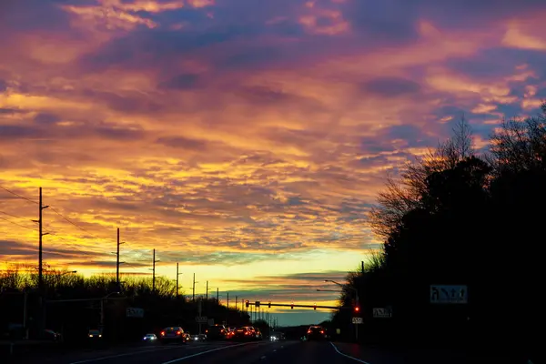 Kleurrijke zonsondergang op het verkeer op de snelweg met auto 's — Stockfoto