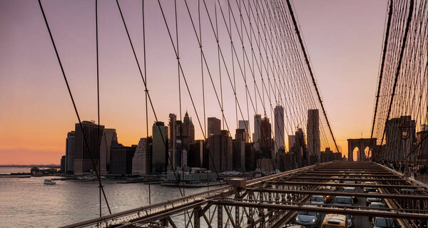 Manhattan skyline with Brooklyn Bridge evening at sunset viewed in summer