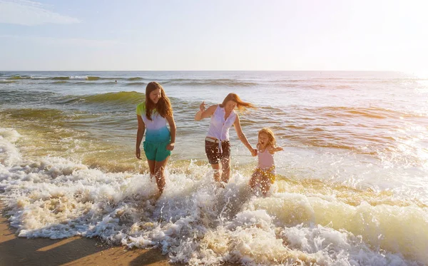 Família brincando na costa do oceano . — Fotografia de Stock